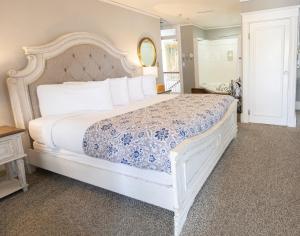 a bedroom with a white bed with a blue and white bedspread at Inn on Charlotte in St. Augustine