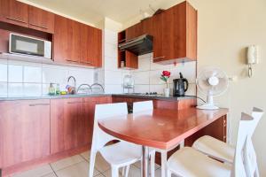 cocina con mesa de madera y sillas blancas en Encantador Departamento 2 Dormitorios, 2 baños, en Santiago