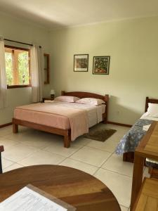 1 dormitorio con 1 cama grande en una habitación en Pousada Colar de Ouro en Cunha