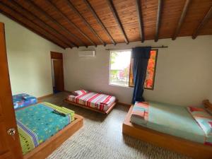 een kamer met 2 bedden en een raam bij FINCA HOTEL BUENOS AIRES DORADAL in Puerto Triunfo
