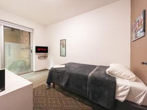 Un dormitorio con una cama grande y una ventana en Puerta Condesa, Rooms & Studios, en Ciudad de México