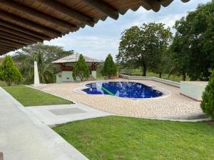 een zwembad in een tuin naast een huis bij FINCA HOTEL BUENOS AIRES DORADAL in Puerto Triunfo