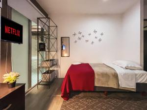 1 dormitorio con 1 cama con manta roja en Puerta Condesa, Rooms & Studios, en Ciudad de México