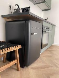 um frigorífico preto numa cozinha com um fogão em T2 neuf avec Parking et terrasse em Toulon