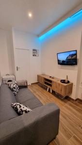 a living room with a couch and a flat screen tv at Appartement cosy 30 m² proche RER B - 4 min à pied in Aulnay-sous-Bois