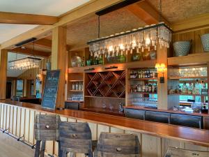 a bar with a wooden counter and some chairs at The Leland Lodge 