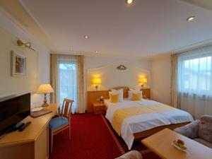 a hotel room with a bed and a desk at Schedlers Löwenhotel-GARNI in Alberschwende