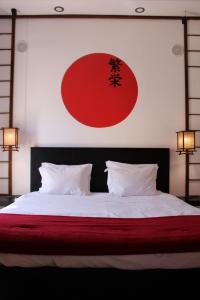 a bedroom with a large bed with a red and white bedspread at Zen Museu do Bonsai in Sintra