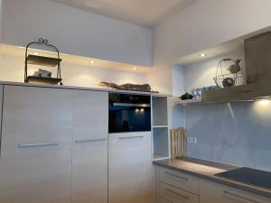 a kitchen with white cabinets and a counter top at Strandappartement Festival met 2 slpk in Knokke
