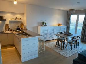 a kitchen and dining room with a table and chairs at Strandappartement Festival met 2 slpk in Knokke
