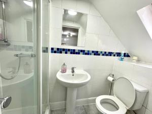 W łazience znajduje się toaleta, umywalka i prysznic. w obiekcie 4 Bedrooms, 3 bathrooms , Reception, Kitchen, Garden, FullHouse w Londynie