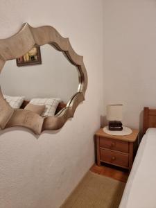 1 dormitorio con espejo, cama y mesa en Apartment Matej, en Trogir