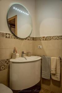 a bathroom with a white sink and a mirror at La Corte GIO' in Taurisano