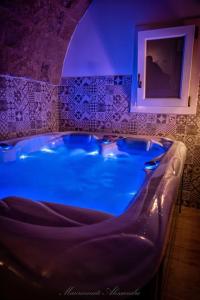 a large tub in a bathroom with blue lighting at La Corte GIO' in Taurisano