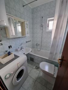 Baño blanco con aseo y lavamanos en Apartment Matej, en Trogir