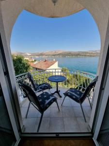 balcón con sillas y mesa con vistas al agua en Apartment Matej, en Trogir