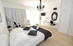 a white bedroom with a large bed and a mirror at Tinel Superior Residence in Zadar