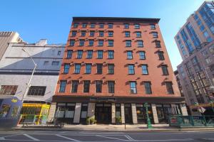 un edificio alto de ladrillo rojo en una calle de la ciudad en The Frederick Hotel Tribeca, en Nueva York