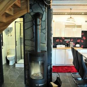 a living room with a fireplace in a kitchen at Domki u Biesiady in Lesko