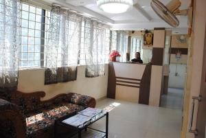 a woman standing at a counter in a waiting room at Just Guest House, Chennai Airport in Chennai