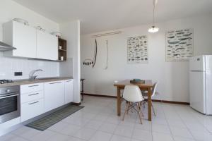 a white kitchen with a table and a white refrigerator at Casa Almyrà Costa dei trabocchi in Fossacesia