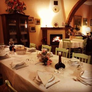 a table with a white table cloth and a fireplace at Agriturismo Campo Al Sole in Castell’Anselmo