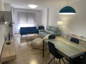 a living room with a table and a blue couch at Apartamento Pandora, ideal para sentirte como en casa in Villena