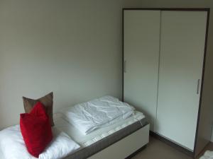a bedroom with a bed with a red pillow on it at GWG City Apartments II in Halle an der Saale
