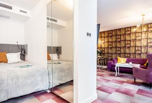 a bedroom with a king sized bed and a purple couch at oompH Wrocław Deluxe Apt Ruska in Wrocław
