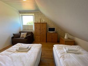 a attic bedroom with two beds and a couch at Kleemann´s Apartment**** in Zossen