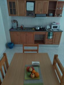 a kitchen with a wooden table with fruits on it at IMOBITUR-Tourist Apartments- Palmarejo Centro AV SV in Praia
