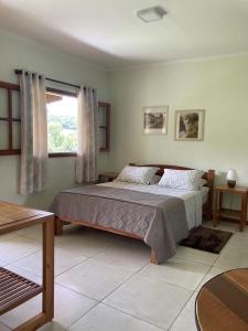 a bedroom with a bed and a window at Pousada Colar de Ouro in Cunha