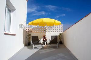 a patio with two chairs and a yellow umbrella at Casa La Balaustrada in Valverde