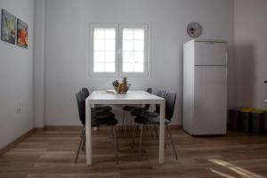 a white table with black chairs and a white refrigerator at Casa La Balaustrada in Valverde