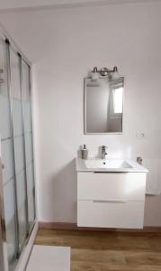 a white bathroom with a sink and a mirror at Casa La Balaustrada in Valverde