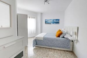 Habitación blanca con cama y TV en Casa La Balaustrada en Valverde