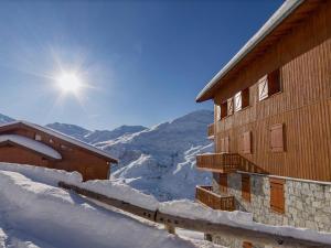 un edificio coperto di neve con il sole nel cielo di Appartement Les Menuires, 4 pièces, 12 personnes - FR-1-452-86 a Les Menuires