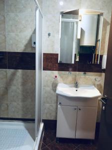 un bagno con lavandino e doccia con specchio di Beautiful apartment right by the sea, Sveti Vlas a Sveti Vlas