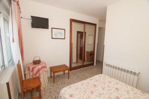 a bedroom with a bed and a table and a mirror at Hotel Costa de Ajo in Ajo