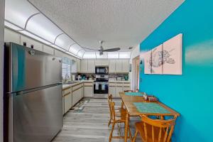a kitchen with a refrigerator and a table with chairs at The Englewood Twin Palms in Englewood