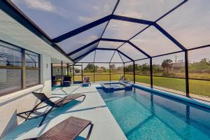 a swimming pool with two chairs and a large window at The Englewood Twin Palms in Englewood
