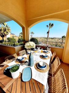 una mesa con sillas y una mesa con vistas al desierto en Dúplex a estrenar 4hab Altaona Golf piscina playa, en Murcia