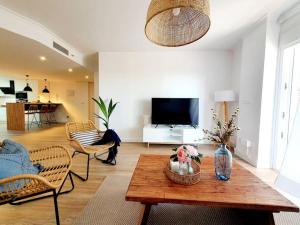 ein Wohnzimmer mit Tisch und Stühlen und einem Fernseher in der Unterkunft Dúplex Amelia Altaona Golf in Murcia