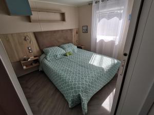 a small bedroom with a bed and a window at Bonne anse plage in Les Mathes