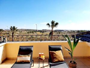 2 Stühle auf einem Balkon mit Blick auf die Wüste in der Unterkunft Dúplex Amelia Altaona Golf in Murcia