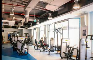 a gym with rows of treadmills and a person sitting in a chair at Charming spacious studio apartment in the heart of JBR By SWEET HOMES in Dubai