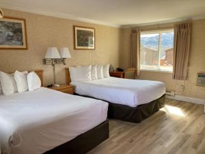 a hotel room with two beds and a window at Blue Door Inn in Estes Park