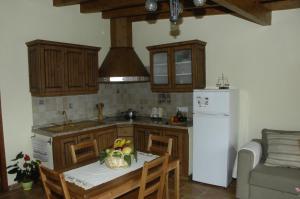 cocina con mesa y nevera blanca en Casa rural Las Palmeras, en Vallehermoso