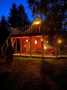 un niño parado frente a una cabaña por la noche en Metsaräägu Wellness 