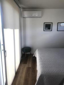 1 dormitorio con 1 cama y 1 silla en Terrazas Suites Cabañas Boutique en Tandil